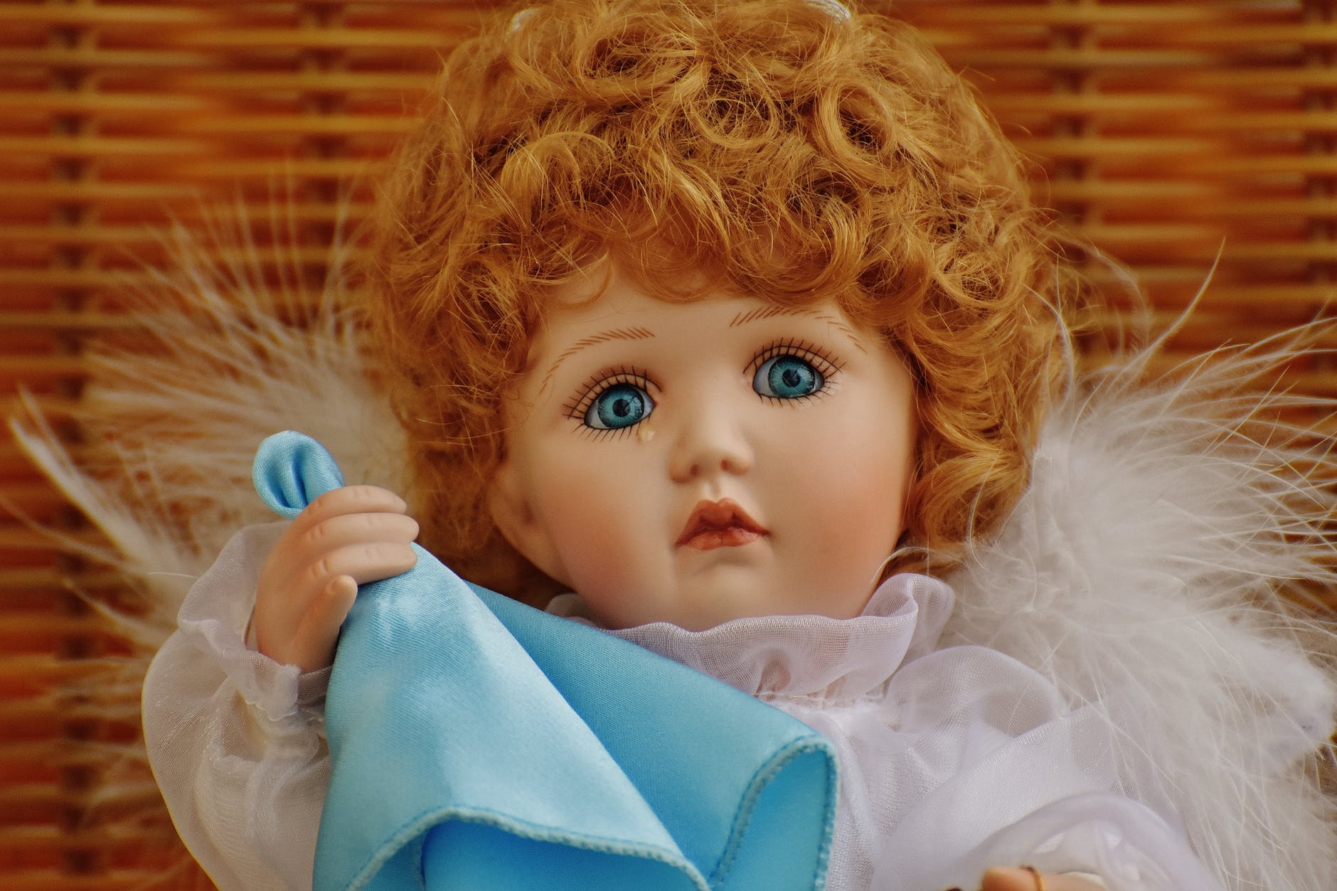 girl doll in white fur dress holding blue handkerchief